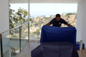 mover wrapping a couch with a view in los angeles